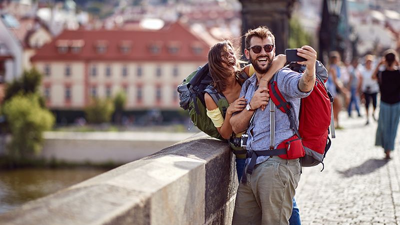 couple with backpacks taking selfie