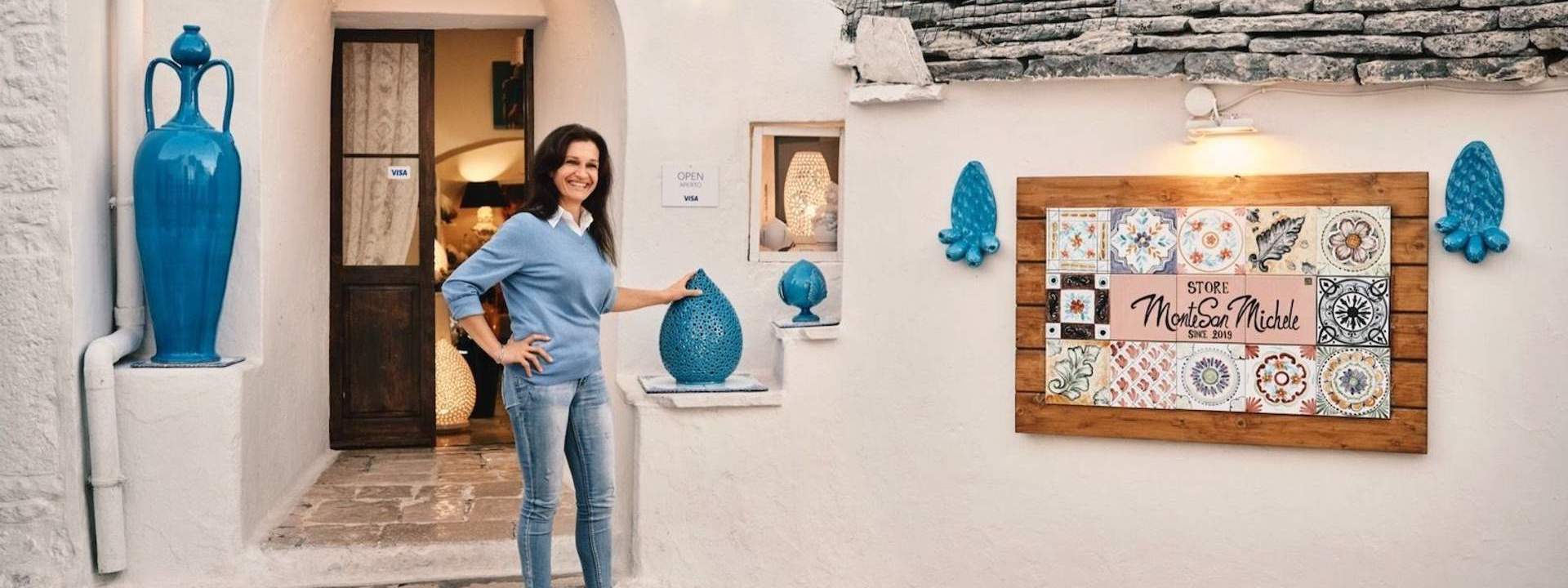 woman posing in front of a ceramic shop