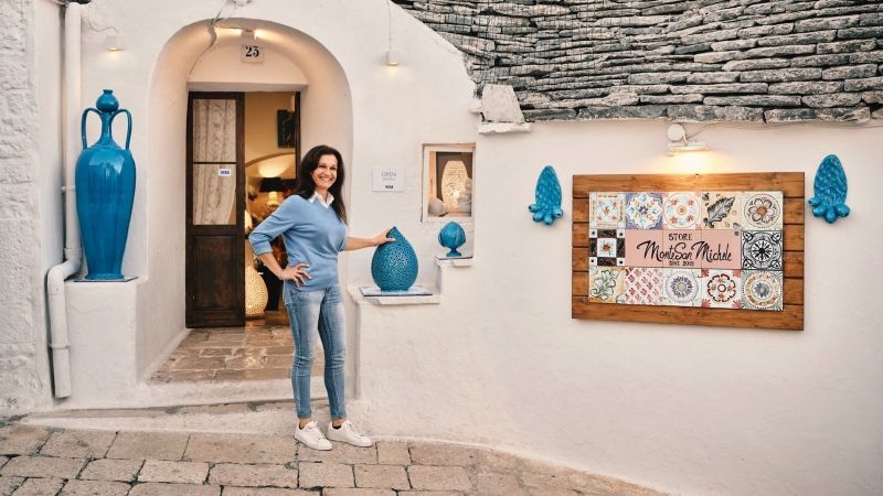 woman posing in front of a ceramic shop